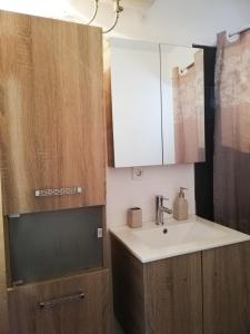 ein Bad mit einem Waschbecken und einem Spiegel in der Unterkunft Explore Greece from Cozy City Centre Apartment in Chalkida