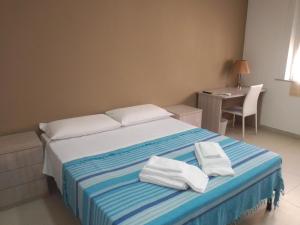 a bedroom with a bed with white towels on it at MAGNA GRECIA B&B in Reggio Calabria
