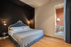 Schlafzimmer mit einem großen Bett mit blauem Kopfteil in der Unterkunft Mysuiteshome Apartments in Bologna