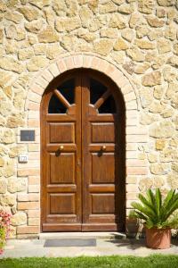 a large wooden door in a stone building at Il Fornello in Volterra