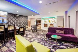 エルクハートにあるLa Quinta Inn and Suites by Wyndham Elkhartの紫色のソファと椅子、バーが備わるロビー