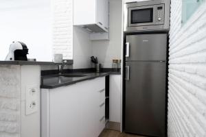 uma cozinha com um frigorífico de aço inoxidável e um micro-ondas em Apartamento a estrenar en primera linea de playa - Rio de Janeiro Beach em Algarrobo