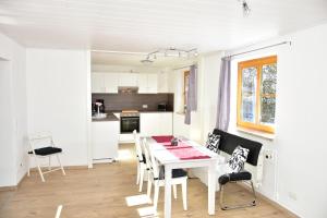 een keuken en eetkamer met een witte tafel en stoelen bij Ferienwohnung Lohra in Lohra