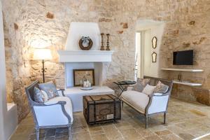 een woonkamer met twee stoelen en een open haard bij Borgo Fantese in Ostuni