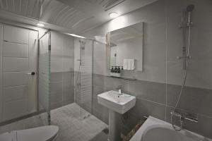 a bathroom with a sink, toilet and bathtub at Busan Beach Hotel Busan Songdo in Busan