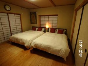 1 dormitorio con 2 camas y reloj en la pared en Aso - House / Vacation STAY 79474 en Aso