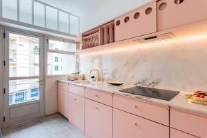 uma cozinha com armários cor-de-rosa e um lavatório em AMAZING DUPLEX - Mid Century Experience & PARKING em Porto