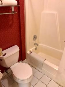 a white toilet sitting next to a bath tub in a bathroom at Main Street Motel in Fish Creek