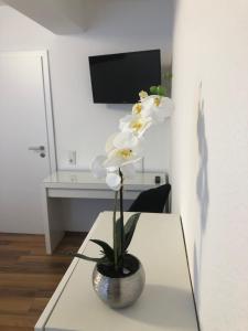 un jarrón de flores blancas sentado en una mesa en City Rooms, en Goch