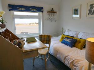 a bedroom with a bed and a desk and a window at The Light House in Bideford