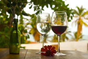 two glasses of wine and a bottle on a table at Vila Retiro in Aracati