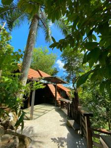 een gebouw met een palmboom en banken ervoor bij Langit Rimba Resort in Seremban