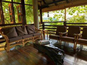 een woonkamer met een bank en 2 stoelen bij Langit Rimba Resort in Seremban