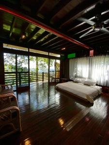 a bedroom with a large bed in a room with windows at Langit Rimba Resort in Seremban