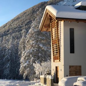 a building with a snow covered mountain in the background at Bucherhof in Obsteig