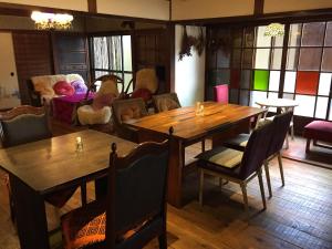 een eetkamer met houten tafels en stoelen bij kominka villa Awa 淡 in Ikuta