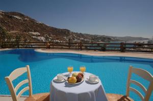 a table with a plate of fruit next to a swimming pool at Paradision Hotel in Tourlos