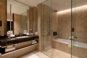 a bathroom with a large mirror and a tub at The Okura Tokyo in Tokyo