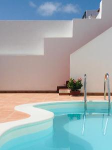 einem Pool vor einem Gebäude in der Unterkunft Surfers Retreat in Corralejo