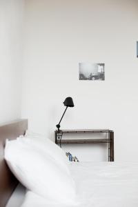a white desk with a lamp on a white wall at Maison Sainte-Marguerite in Liège