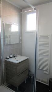 La salle de bains est pourvue d'un lavabo, d'un miroir et d'une fenêtre. dans l'établissement Sweethome-Epinal, à Épinal