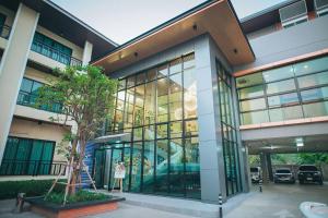 a large glass building with a tree in front of it at Morage Hotel in Phitsanulok