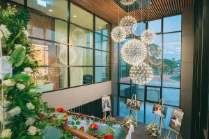 a room with windows and flowers and lights at Morage Hotel in Phitsanulok
