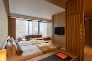 um quarto com uma cama grande e uma televisão em The Okura Tokyo em Tóquio