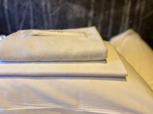 a stack of towels sitting on top of a bed at Hostel SAMURISE Mt Fuji in Fujikawaguchiko