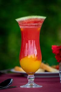 a red drink in a glass on a table at Home of Friends in Kapchorwa