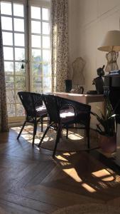 een woonkamer met een tafel en stoelen en een raam bij Chambre d'hôte du Château in Dourdan