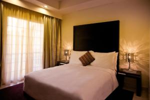 Un dormitorio con una gran cama blanca y una ventana en Mövenpick Beach Resort Al Khobar, en Bahía de la Media Luna