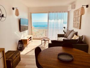 een woonkamer met uitzicht op de oceaan bij "MER" Séjour détente tout confort, magnifique vue sur la mer in Canet-en-Roussillon