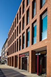 un bâtiment en briques rouges avec un panneau d'hôtel aindersbury dans l'établissement IntercityHotel Hamburg-Barmbek, à Hambourg