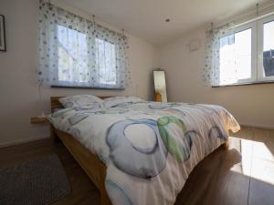 a bedroom with a large bed in a room with windows at 16Lilien Apartmentwohnung in Waiblingen