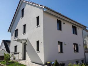 ein großes weißes Gebäude mit seitlicher Treppe in der Unterkunft 16Lilien Apartmentwohnung in Waiblingen