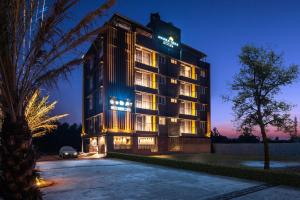 班加罗尔Hotel Avora Tree By Rivido Kempegowda Airport Road的夜间酒店,门前有停车场
