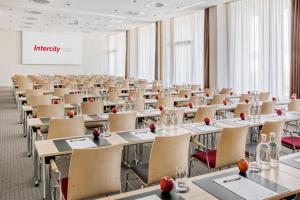 an empty room with tables and chairs and a whiteboard at IntercityHotel Hamburg-Barmbek in Hamburg