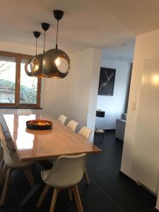 uma sala de jantar com uma mesa de madeira e cadeiras em Villa Odile em Malmedy