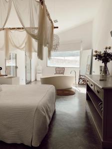 sypialnia z dużym łóżkiem i wanną w obiekcie La Maga Rooms w mieście Xàtiva