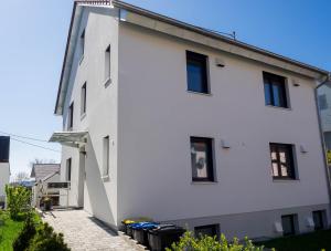 a white building with black windows at 16Lilien Apartmentwohnung Gartenblick in Waiblingen