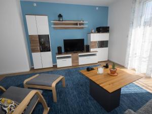 a living room with a table and a tv at 16Lilien Apartmentwohnung Gartenblick in Waiblingen