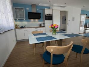 a kitchen with a table with chairs and a vase of flowers at 16Lilien Apartmentwohnung Gartenblick in Waiblingen