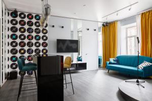 a living room with a blue couch and a tv at Roomburg Apartments in Saint Petersburg