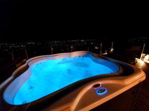 a hot tub on top of a building at night at Bagoly Wellness Apartman in Pécs