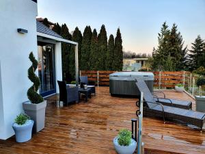 eine Terrasse mit Bänken und einem Whirlpool auf einem Haus in der Unterkunft Bagoly Wellness Apartman in Pécs