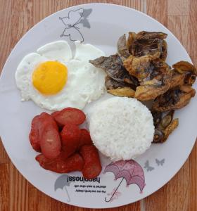 a plate of breakfast food with eggs rice and mushrooms at Ludy's 2 Pension House in Carles