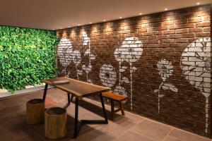 班加罗尔Hotel Avora Tree By Rivido Kempegowda Airport Road的砖墙,有桌子,墙上有画图