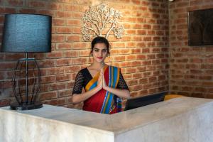 班加罗尔Hotel Avora Tree By Rivido Kempegowda Airport Road的坐在桌子上的带电脑的女人