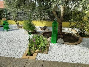 a garden with a green bottle next to a tree at Artistika Golden Apartment in Capitana